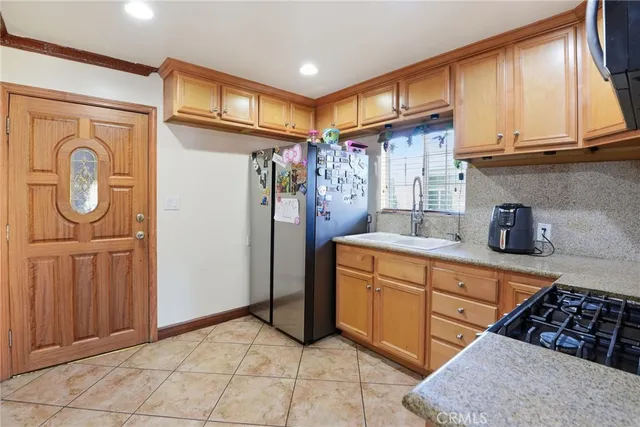 a kitchen with stainless steel appliances granite countertop a refrigerator and a stove top oven