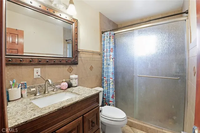 a bathroom with a granite countertop sink toilet and shower