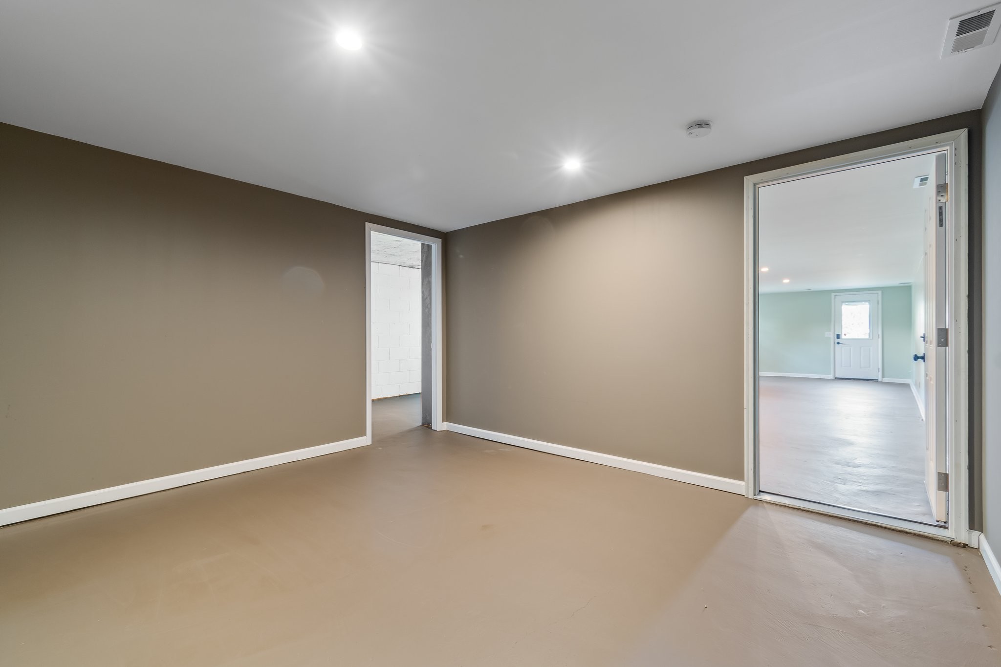 5121 Hilson Road Nashville, TN 37211 - Photo 40 of 63 View of the landing room showing the doorway to the smaller unfinished room to the left and the large finished room on the right, with the private driveway access door at the end. Out of frame to the right is the door to the large unfinished section