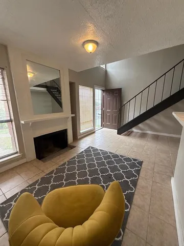 a living room with a rug and a fireplace
