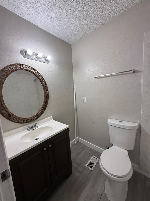 7152 Fair Oaks Avenue, Unit 1181 Dallas, TX 75231 - Photo 4 of 11 a bathroom with a toilet a sink and a mirror