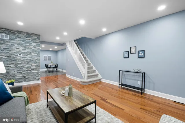 a living room with furniture and a wooden floor