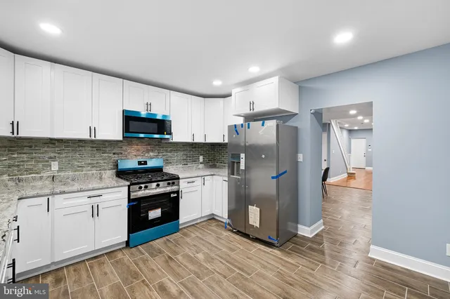 a kitchen with stainless steel appliances granite countertop a refrigerator sink and stove