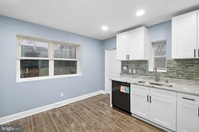 a kitchen with granite countertop white cabinets and white appliances