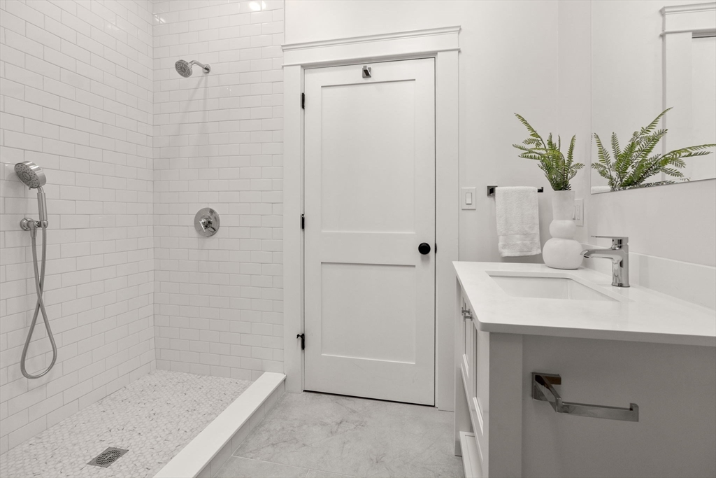 82 Deer Path Lane Weston, MA 02493 - Photo 31 of 42 a bathroom with a sink a mirror a glass door shower and vanity