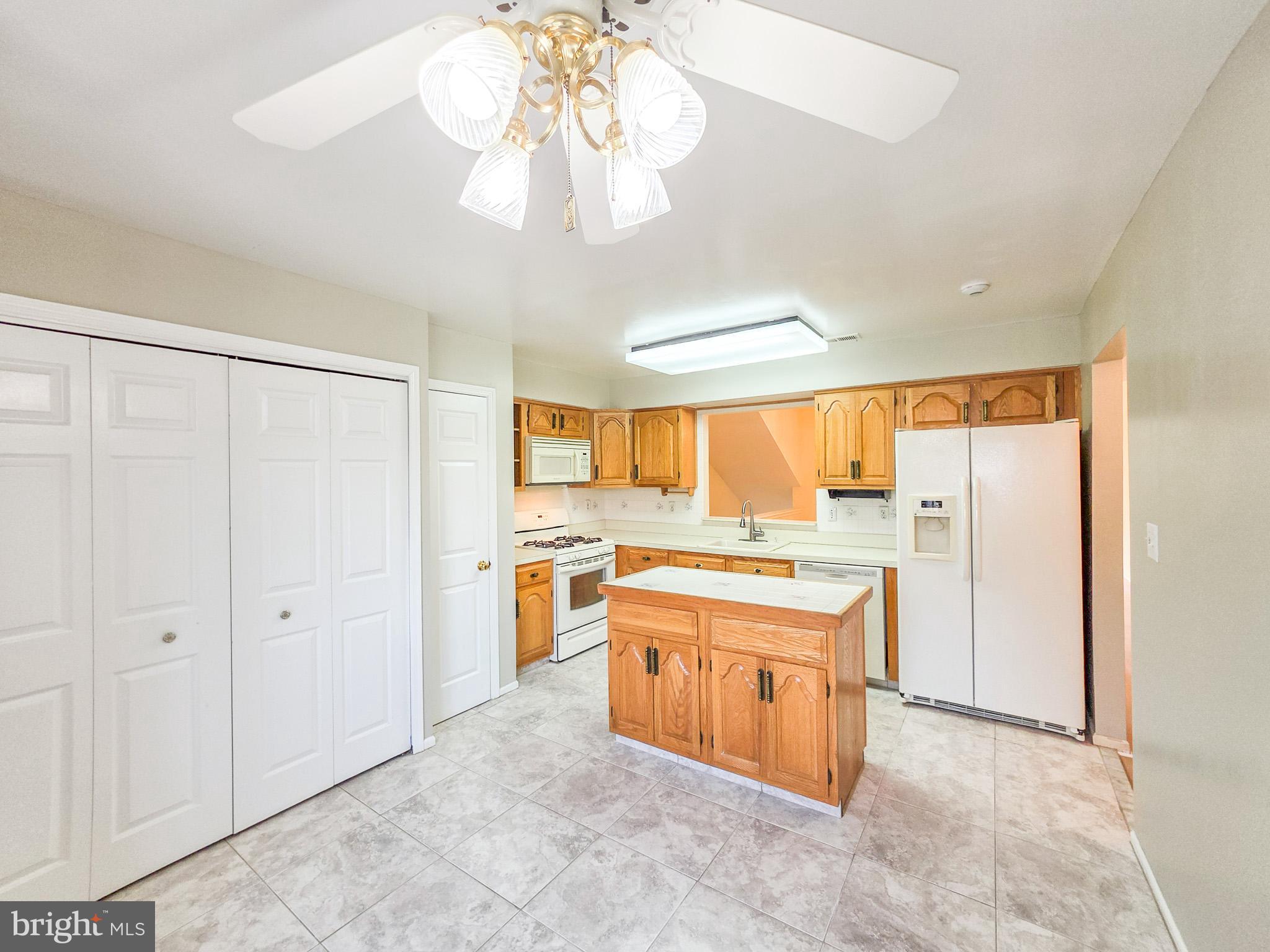 1 Rutland Lane Monroe Township, NJ 08831 - Photo 4 of 26 a large kitchen with a stove a refrigerator and chandelier