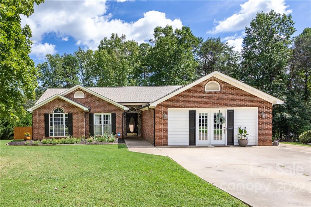 a front view of a house with a yard and trees