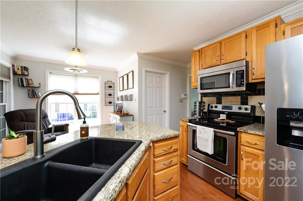 7760 Wallace Lane Denver, NC 28037 - Photo 17 of 48 a kitchen with stainless steel appliances granite countertop a stove a sink and a microwave