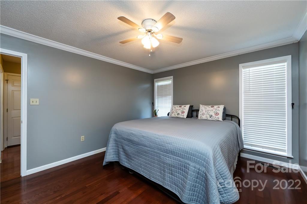 7760 Wallace Lane Denver, NC 28037 - Photo 29 of 48 a bedroom with a bed and a chandelier