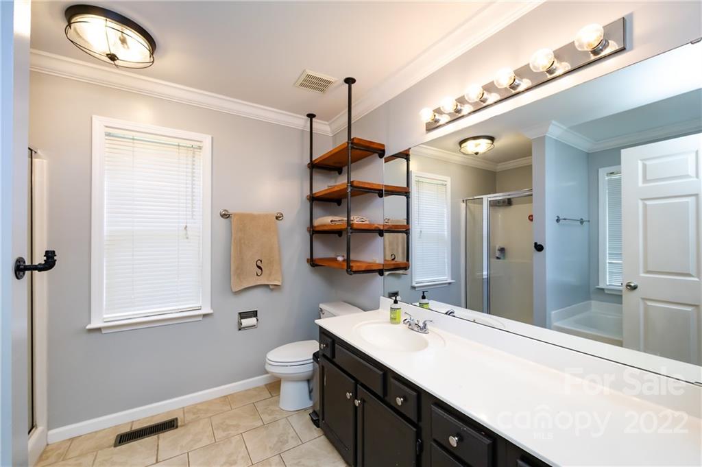 7760 Wallace Lane Denver, NC 28037 - Photo 32 of 48 a spacious bathroom with a granite countertop sink a toilet and a mirror