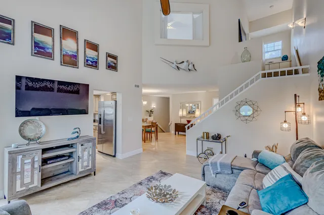 a kitchen with stainless steel appliances granite countertop a refrigerator a sink a stove and white cabinets with wooden floor