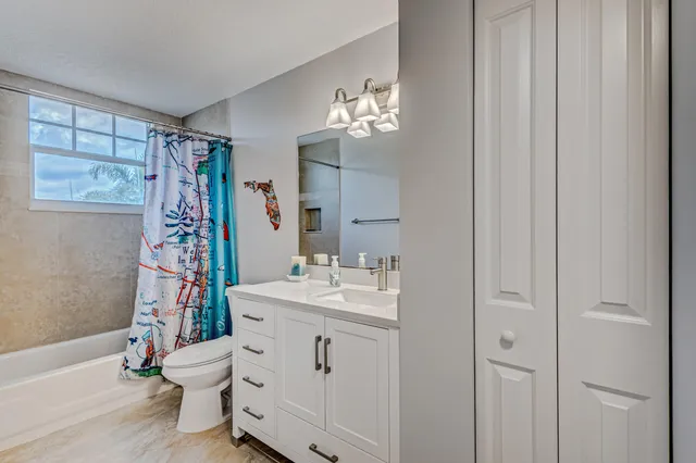 a bedroom with a bed and a table in it with window