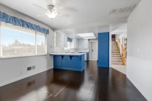 a view of a livingroom with wooden floor and a large window