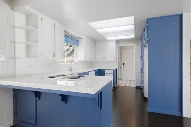 a kitchen with a sink a refrigerator and cabinets