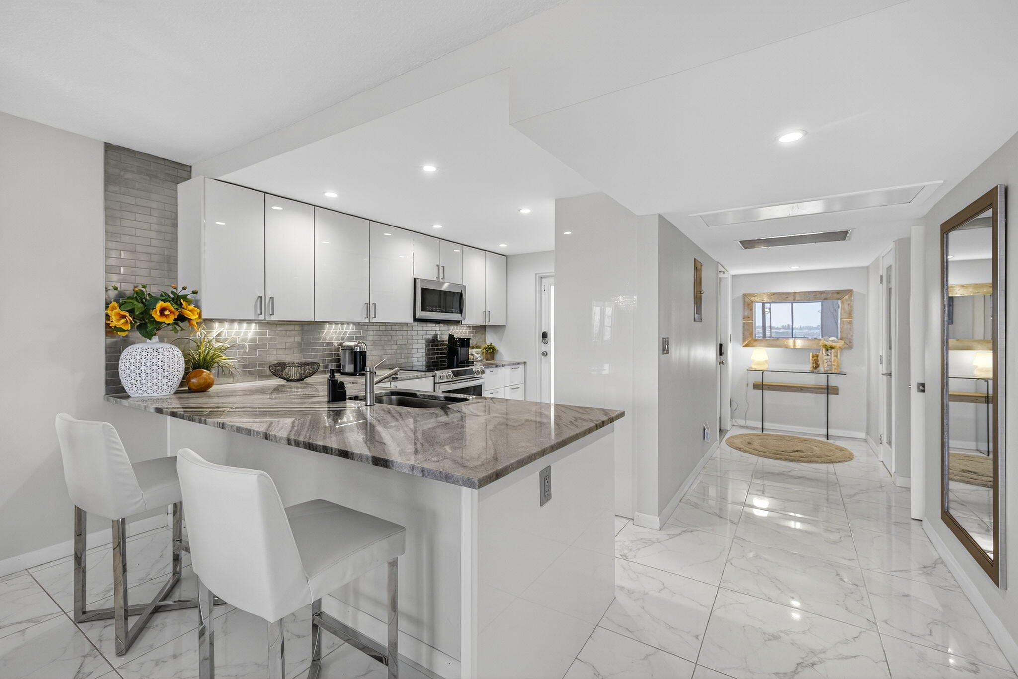 3091 North Course Drive, Unit 710 Pompano Beach, FL 33069 - Photo 19 of 46 a kitchen with stainless steel appliances granite countertop a sink refrigerator and cabinets