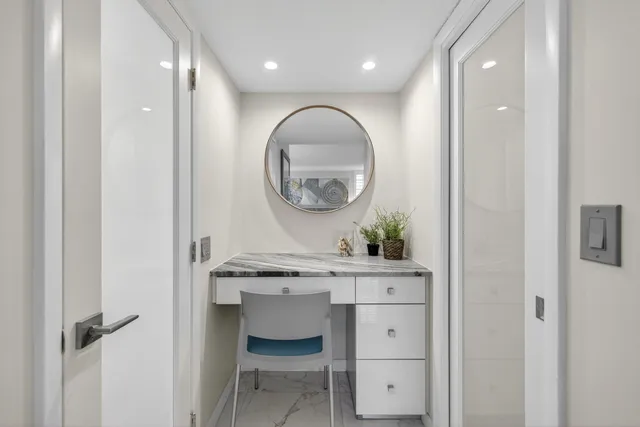 a view of a hallway with a table and chairs