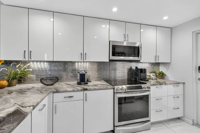 a kitchen with granite countertop a stove a sink and a microwave
