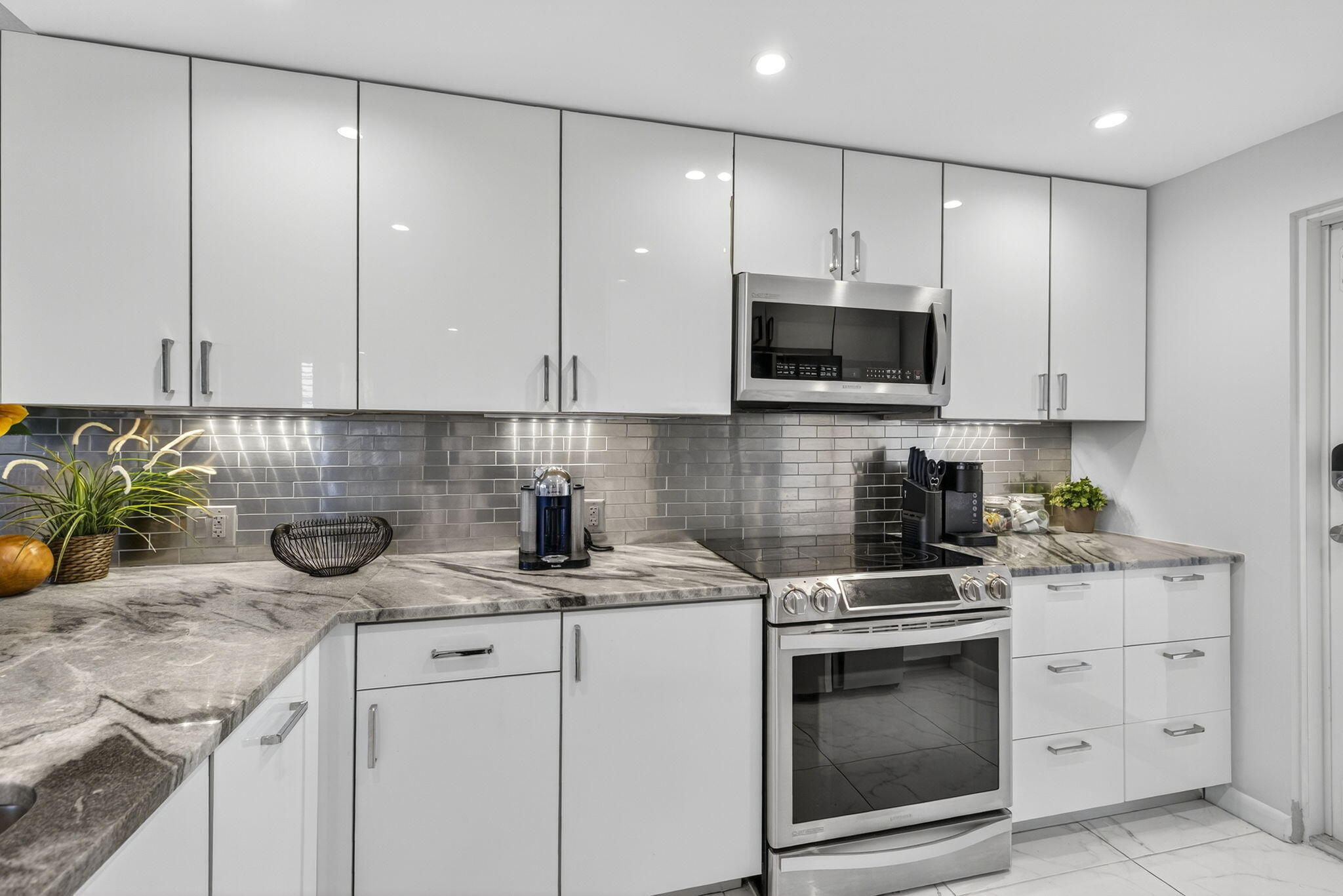 3091 North Course Drive, Unit 710 Pompano Beach, FL 33069 - Photo 3 of 46 a kitchen with granite countertop a stove a sink and a microwave