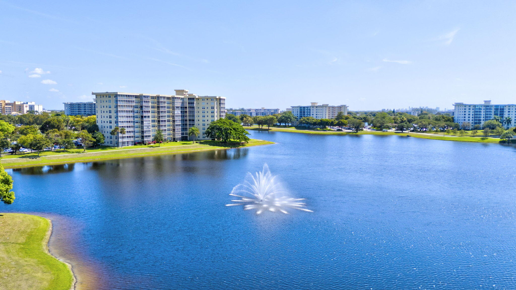 3091 North Course Drive, Unit 710 Pompano Beach, FL 33069 - Photo 37 of 46 a view of a lake with a large building in the background