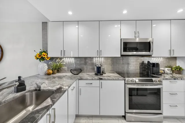 a kitchen with stainless steel appliances granite countertop a sink stove and cabinets