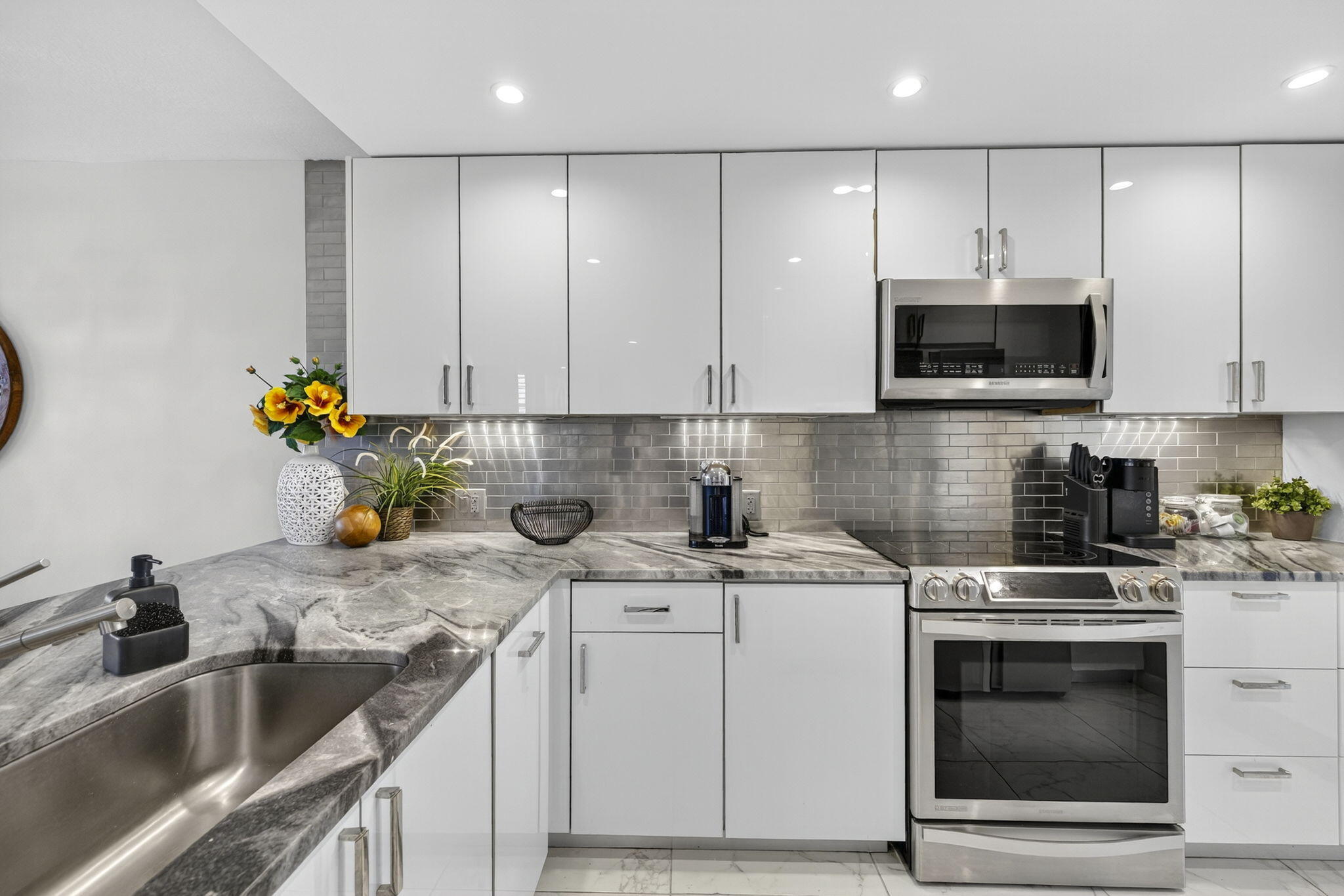 3091 North Course Drive, Unit 710 Pompano Beach, FL 33069 - Photo 4 of 46 a kitchen with stainless steel appliances granite countertop a sink stove and cabinets