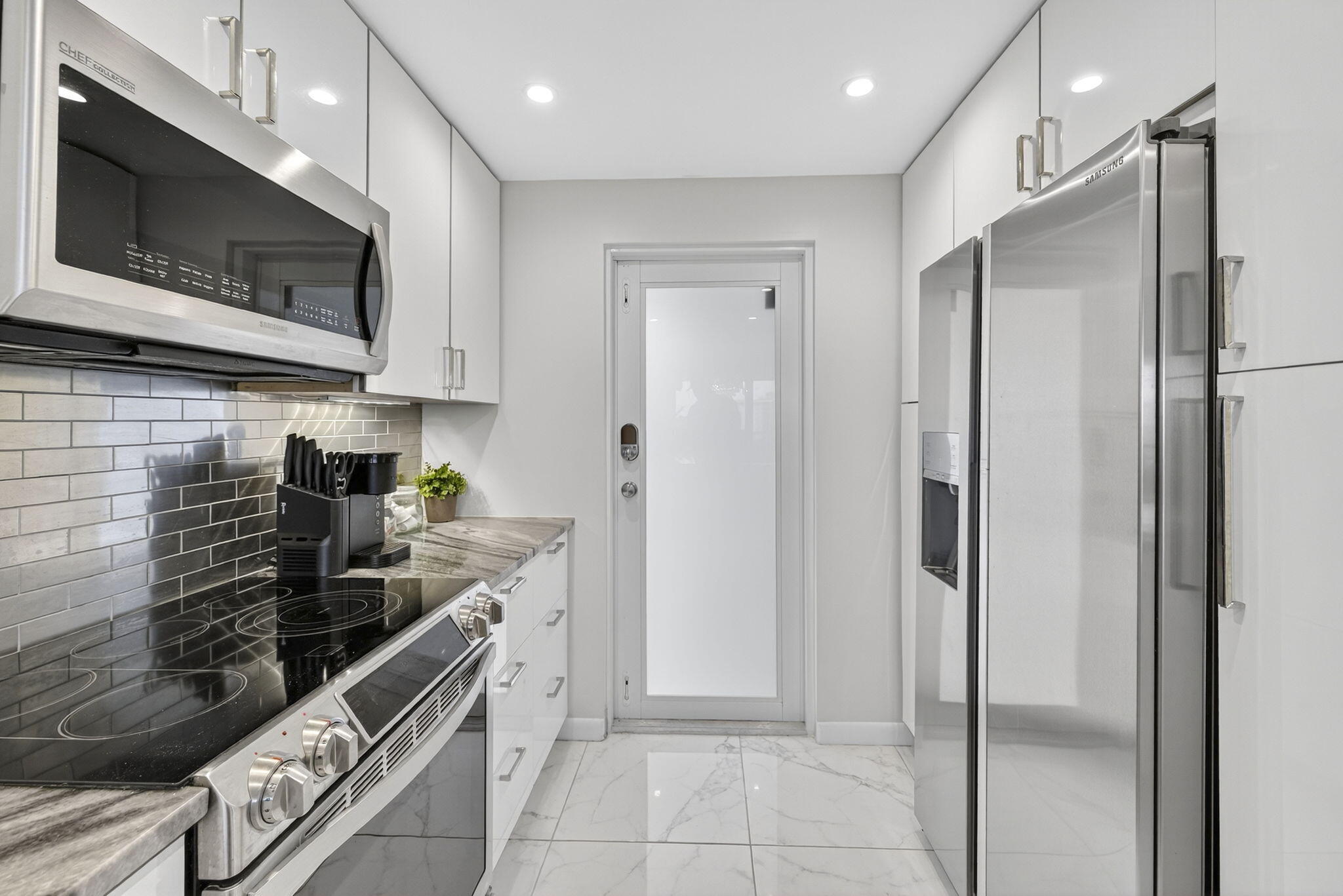 3091 North Course Drive, Unit 710 Pompano Beach, FL 33069 - Photo 7 of 46 a kitchen with stainless steel appliances granite countertop a refrigerator and a stove top oven