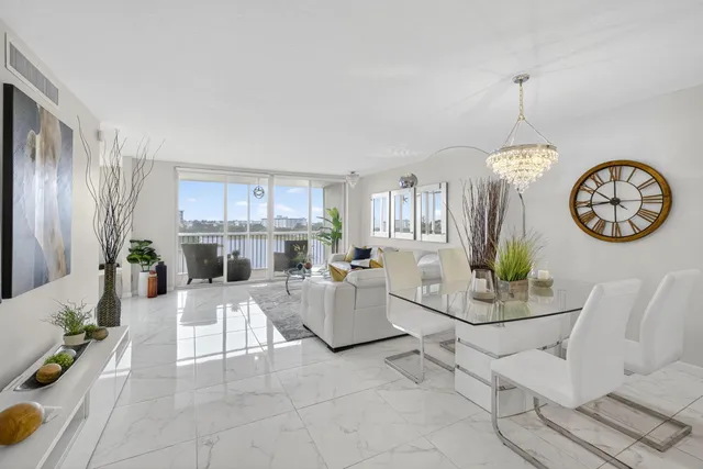 a living room with furniture a clock and a view of kitchen