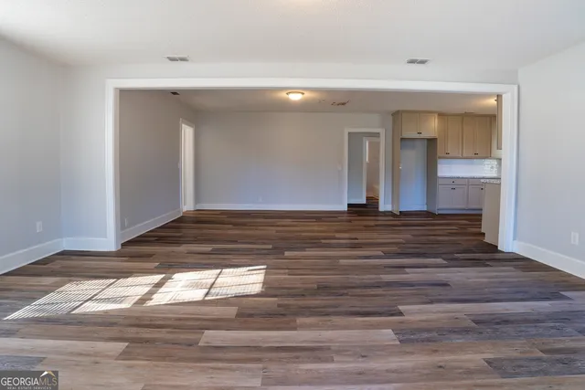 a view of empty room with wooden floor