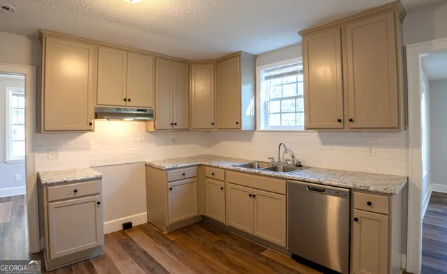 a kitchen with a sink window and cabinets