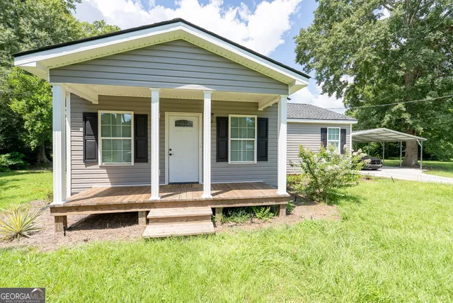 a front view of a house with a yard table and chairs