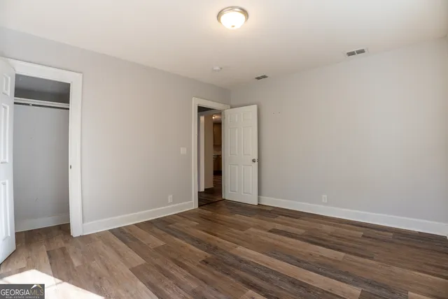 a view of an empty room with wooden floor