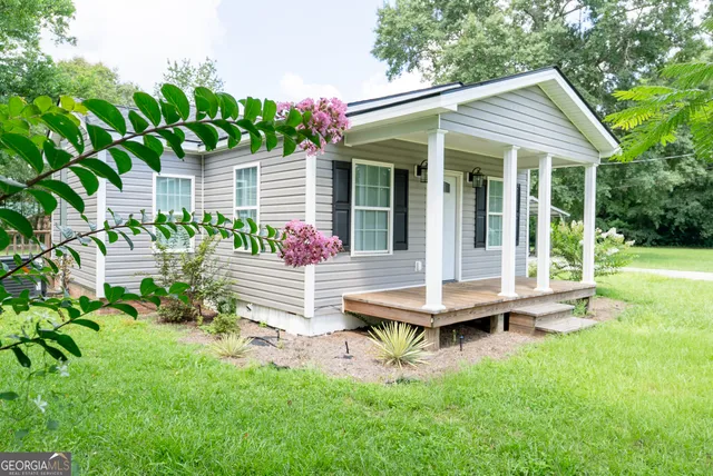 a front view of a house with a garden and patio