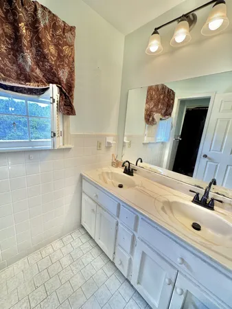 a bathroom with a double vanity sink and a mirror