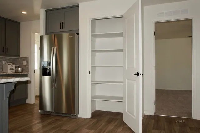 a kitchen with a refrigerator and wooden floor