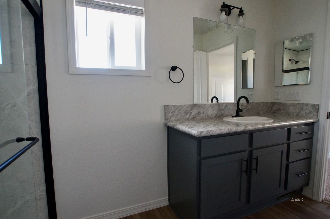 161 Tuolumne Road Bishop, CA 93514 - Photo 10 of 23 a bathroom with a granite countertop sink and a mirror