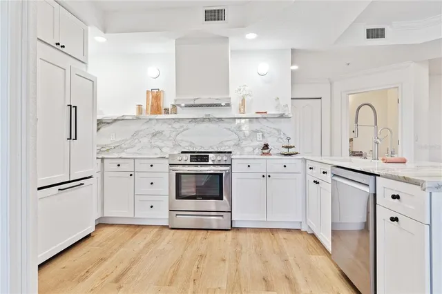 a kitchen with stainless steel appliances a stove sink and refrigerator
