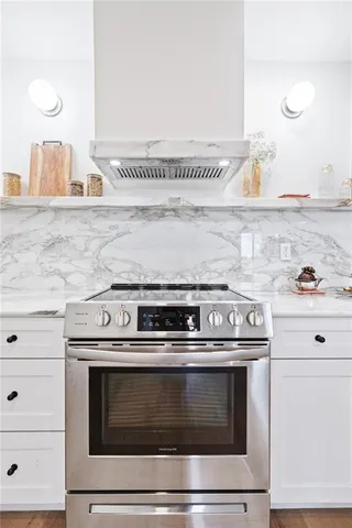 a stove top oven sitting inside of a kitchen