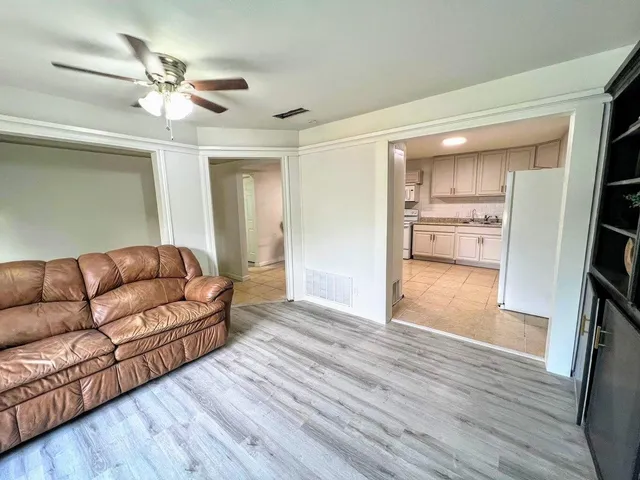 a living room with furniture and a ceiling fan