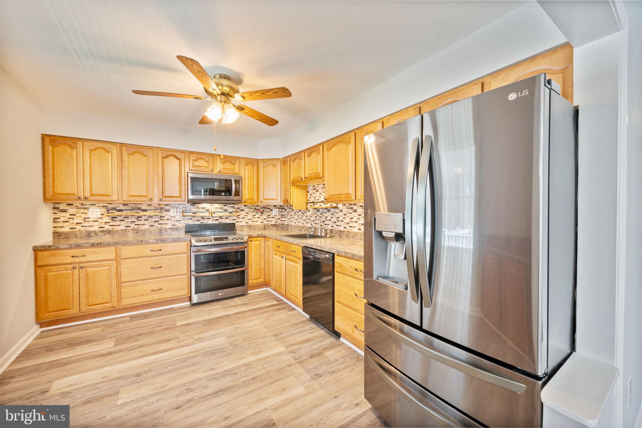 8626 Wise Avenue Baltimore, MD 21222 - Photo 14 of 57 a kitchen with granite countertop stainless steel appliances a refrigerator stove top oven and sink