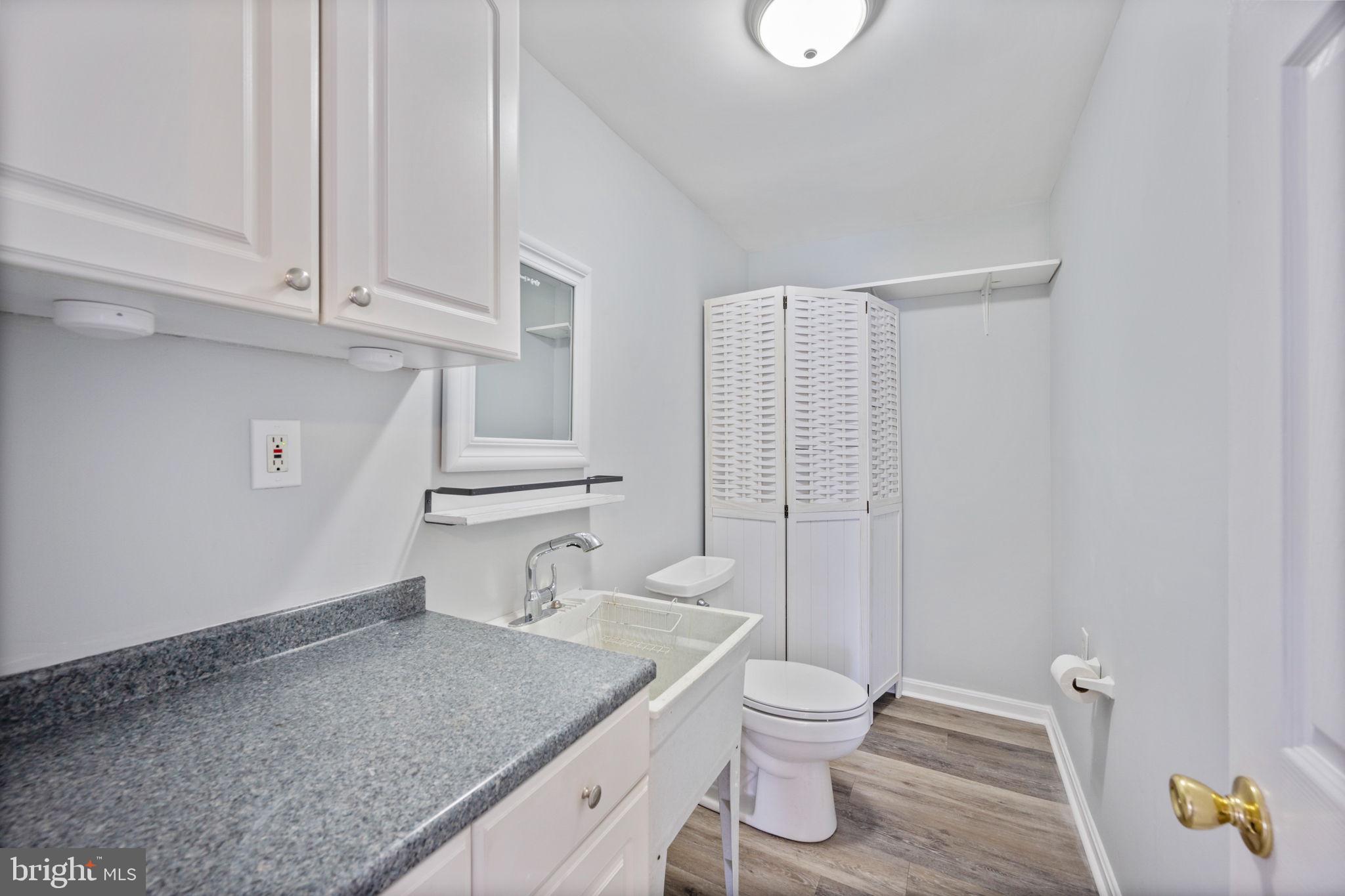 8626 Wise Avenue Baltimore, MD 21222 - Photo 16 of 57 a bathroom with a granite countertop sink toilet and shower