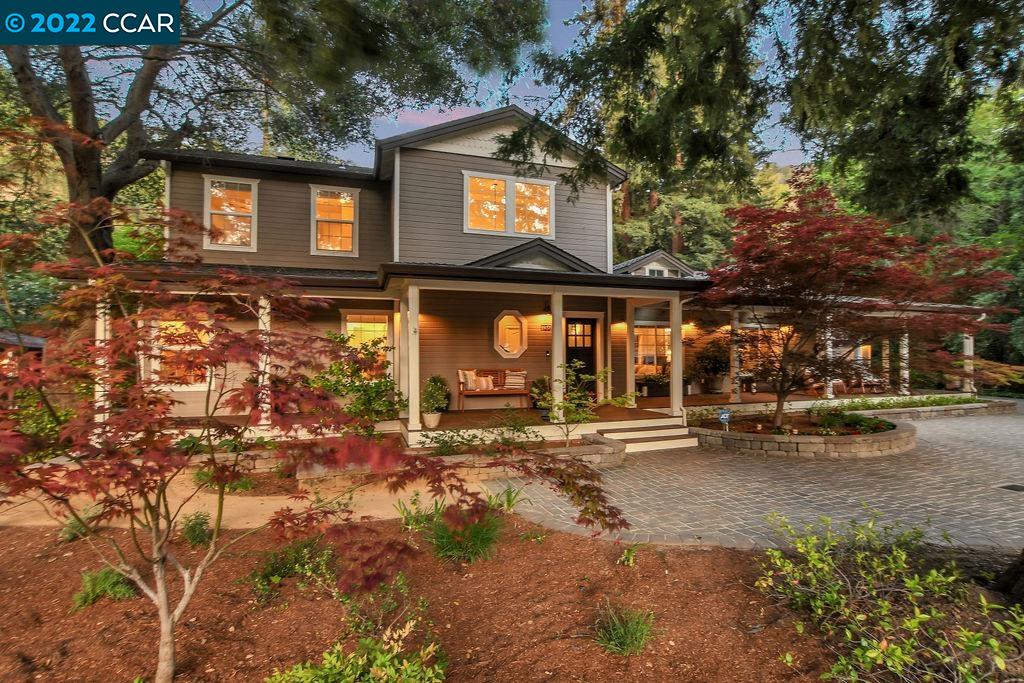 a front view of a house with a tree