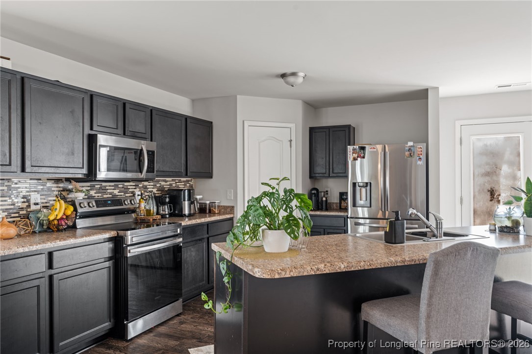 287 Hallow Oak Street Spring Lake, NC 28390 - Photo 11 of 37 a kitchen with granite countertop a sink and cabinets