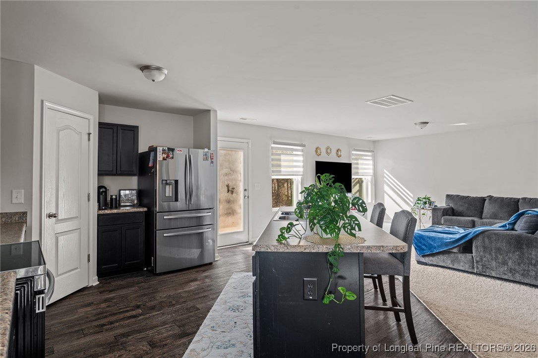 287 Hallow Oak Street Spring Lake, NC 28390 - Photo 12 of 37 a kitchen with stainless steel appliances kitchen island granite countertop a refrigerator and a stove top oven