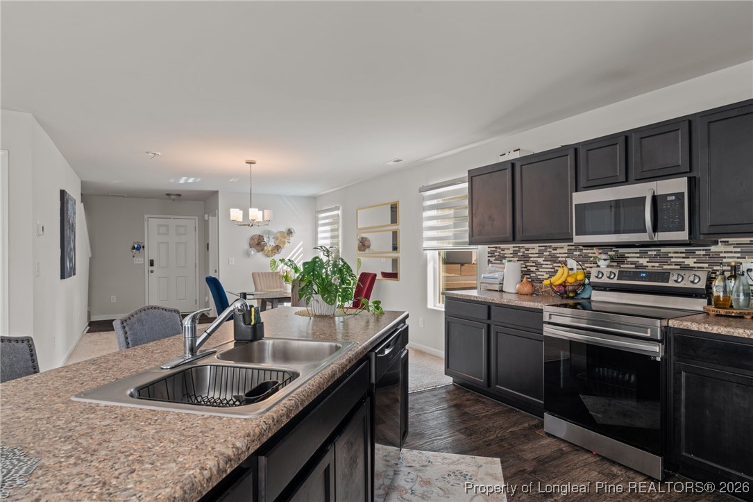 287 Hallow Oak Street Spring Lake, NC 28390 - Photo 13 of 37 a kitchen with stainless steel appliances granite countertop a sink stove and refrigerator