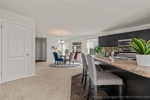 a dining room with furniture and potted plants