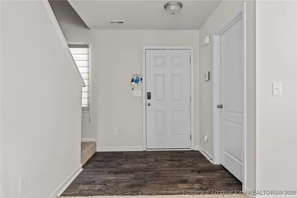 a view of an empty room with wooden floor