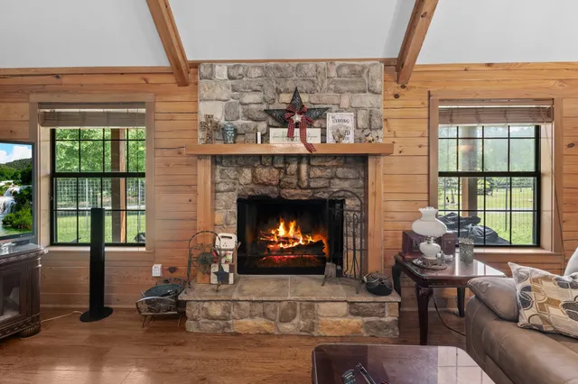 a living room with furniture a fireplace and a floor to ceiling window