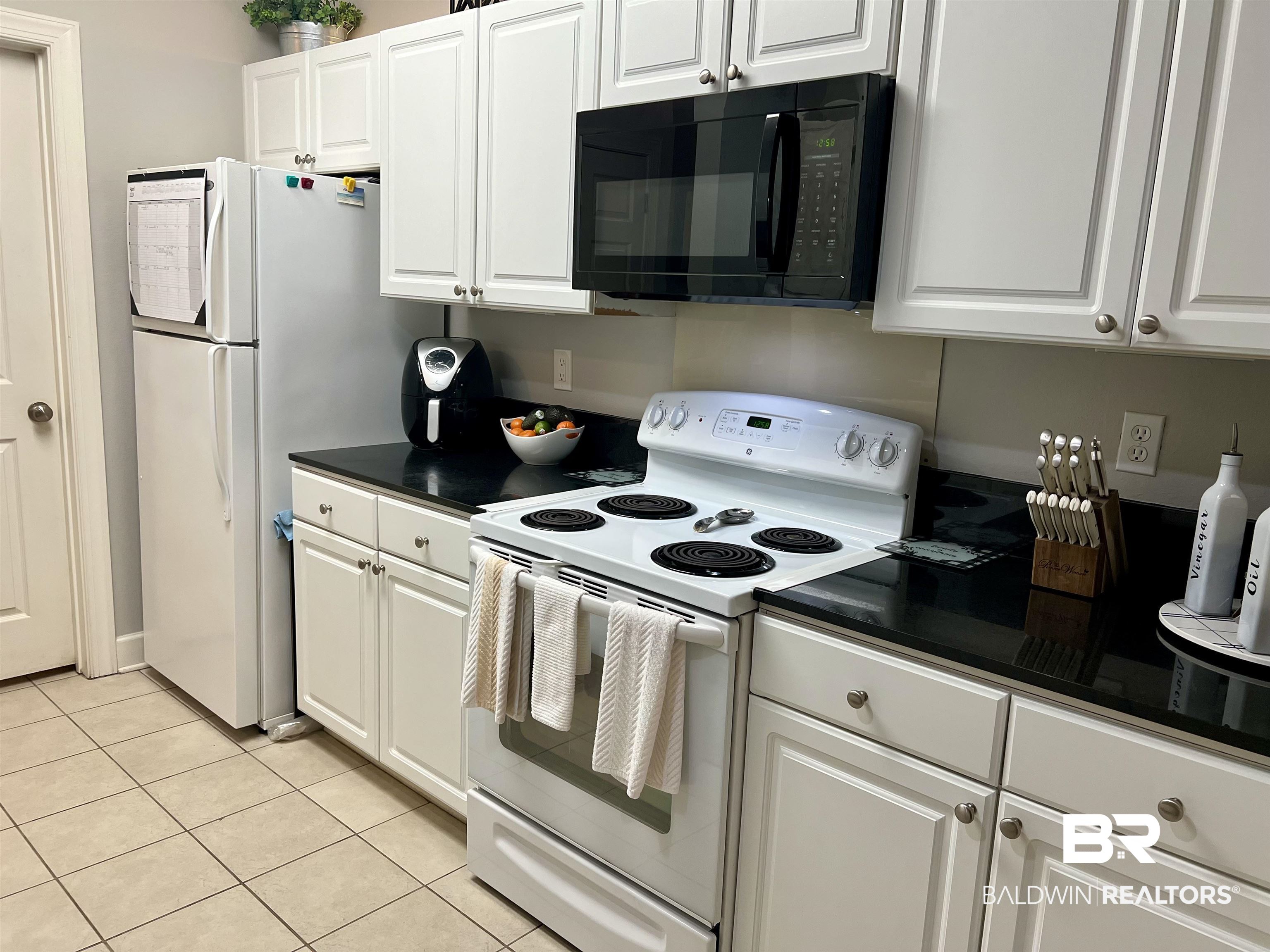 450 Park Avenue, Unit 808 Foley, AL 36535 - Photo 10 of 38 Kitchen featuring white cabinetry, light tile patterned floors, and white appliances