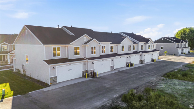 2257 South 1090 West, Unit 74 Nibley, UT 84321 - Photo 32 of 40 Newly constructed townhome community featuring light gray siding, dark roofing, stone accents, two-car garages, and paved driveways
