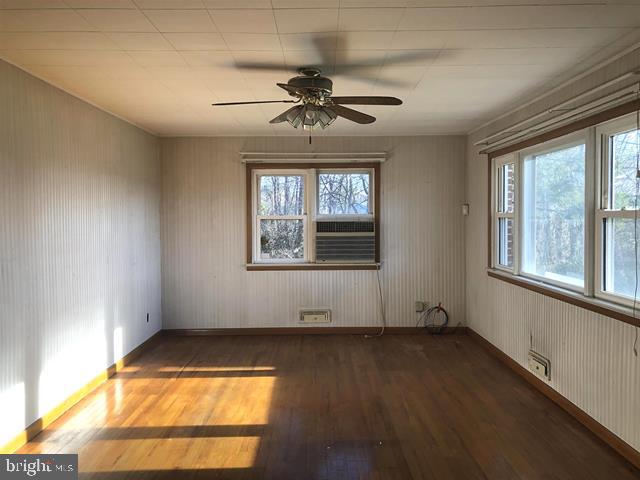 472 Richards Road Bridgeton, NJ 08302 - Photo 10 of 21 an empty room with wooden floor chandelier fan and windows